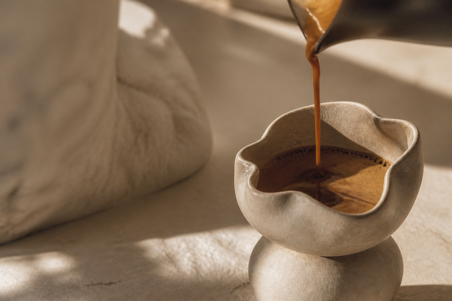 Sculptural ceramic coffee vessel in warm studio light